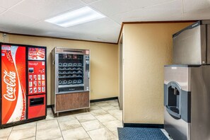 A vending machine area with a Coca-Cola machine, a beverage dispenser, and a refrigerator. - Americas Best Value Inn Searcy (Searcy)