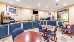 A hotel lobby with a coffee station, seating area, and artwork on the walls. - Americas Best Value Inn Searcy (Searcy)