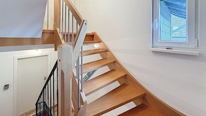 A staircase with wooden steps and black railings leading to a landing. - Wohnung 5 by Interhome (Sankt Goar)