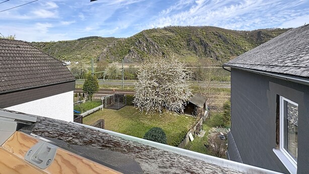 A residential area with a view of a hill, a tree, and a house with a sloped roof. - Wohnung 5 by Interhome (Sankt Goar)