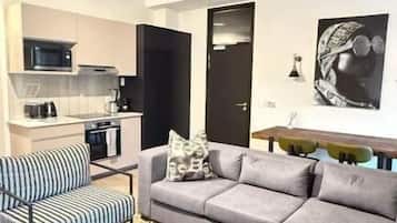 Departamento de lujo, balcón, vista a la ciudad | Área de sala de estar | Televisión de pantalla plana