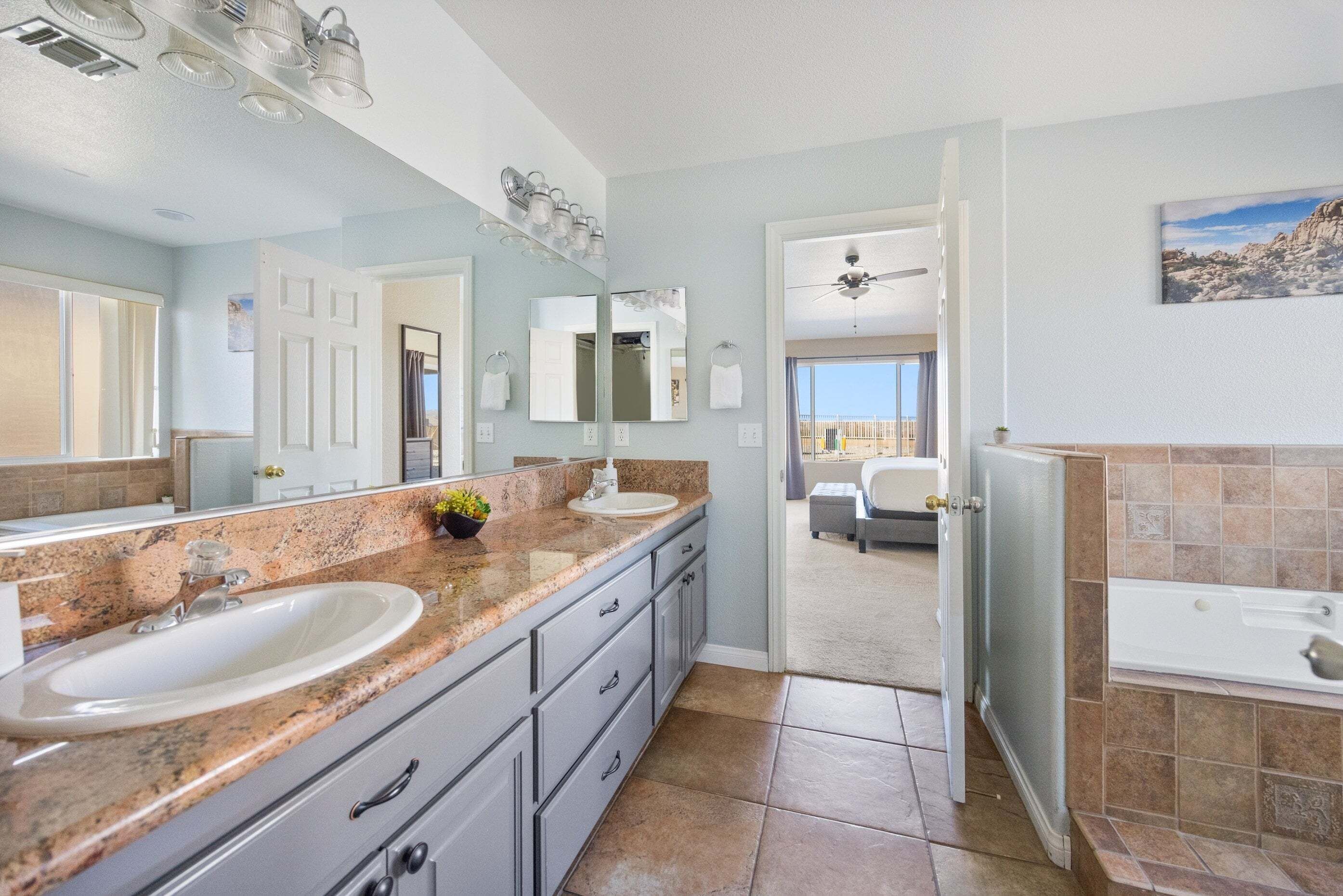A modern bathroom with a large vanity, a bathtub, and a walk-in shower.