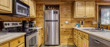 A kitchen with wooden cabinets, stainless steel appliances, and a built-in dishwasher.