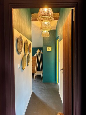 A hallway with a wooden door, a ladder, and wall-mounted decorative plates. - La Grande Rossignol: Pool, spacious rooms, and private bathrooms in Occitanie. (Belvèze)