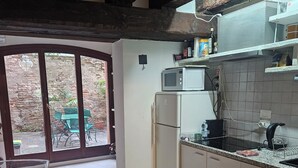 A kitchen with a microwave, refrigerator, and tiled backsplash. - 5 minutes from St. Mark's Square (Venezia)