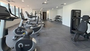 A gym with treadmills, elliptical machines, and weight equipment. - Bloomfields Luxurious 3Br in Al Maryah V (Abu Dhabi)