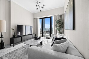 Ein modernes Wohnzimmer mit Flachbildfernseher, Couchtisch und Sofa.
