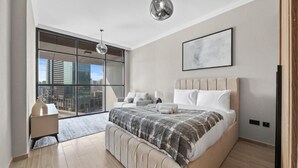 A modern bedroom with a large bed, a desk, and a view of the city through a large window. - Bloomfields Luxurious 3Br in Al Maryah V (Abu Dhabi)
