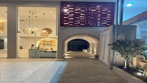 En inomhuskorridor med en reception, en dekorativ vägg och en liten trädgård.