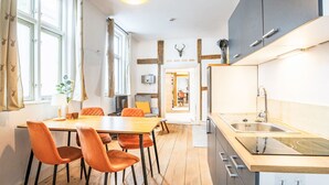 A modern kitchen with a wooden table and chairs, a built-in oven, and a sink. - Königliches Duett by Interhome (Mirow)