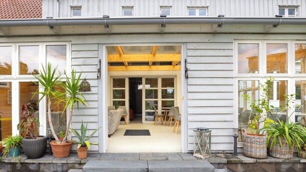 A house with a front porch, steps leading to the entrance, and potted plants. - Königliches Duett by Interhome (Mirow)