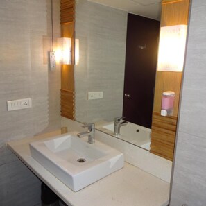 Un baño con dos lavamanos, un espejo y un dispensador de toallas.