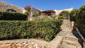 A stone building with a stone staircase leading to a door. - Aegean Whisper Home (Paros)