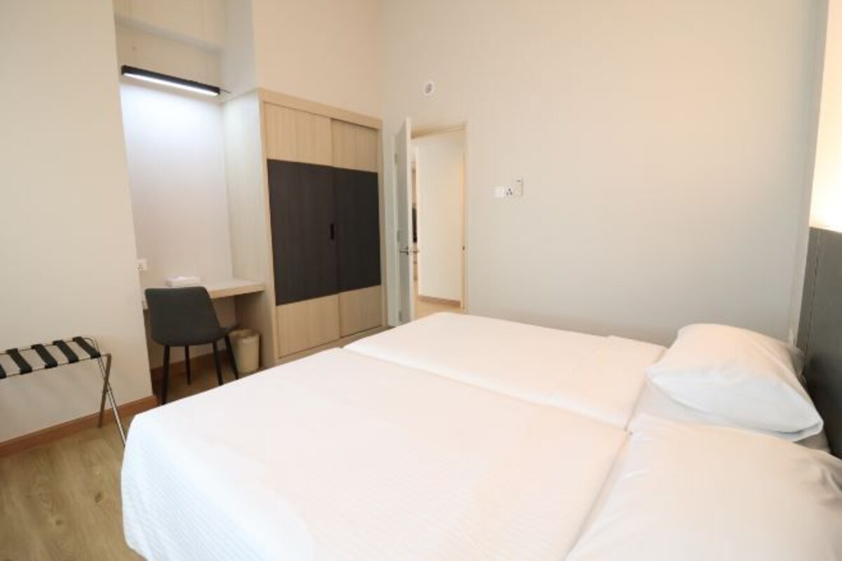 A bedroom with a bed, a desk, and a chair.