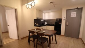 A compact kitchen with a dining area, a microwave, and a coffee maker. - Crown Regency Serviced Suites (Kuala Lumpur)