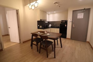 A compact kitchen with a dining area, a microwave, and a coffee maker. - Crown Regency Serviced Suites (Kuala Lumpur)