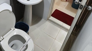 A small bathroom with a toilet, sink, and hand dryer. - Hotel Sogo Cartimar Recto (Manila)