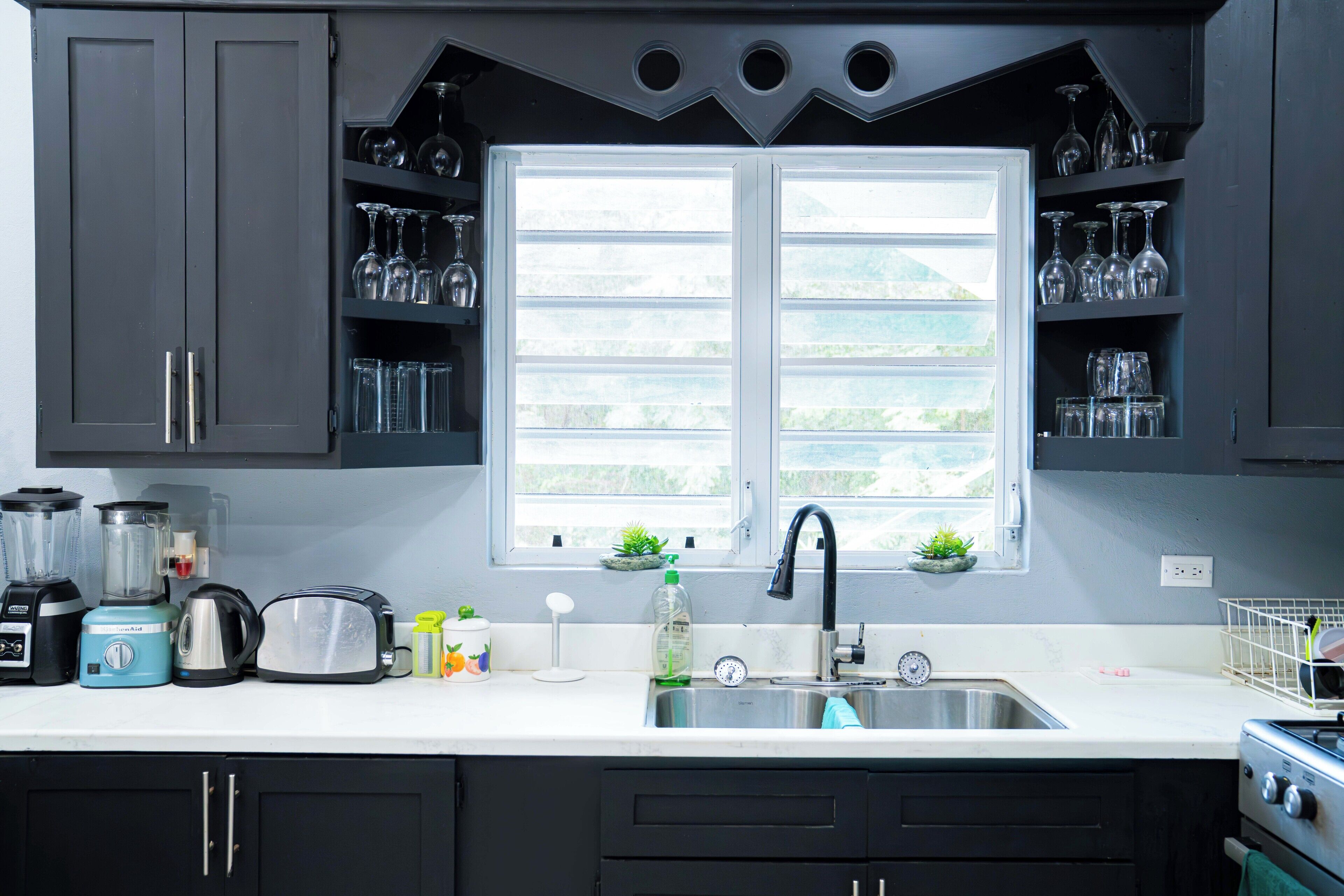 A kitchen with a window, a sink, and various appliances.