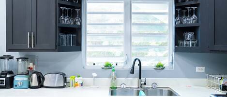 A kitchen with a window, a sink, and various appliances.
