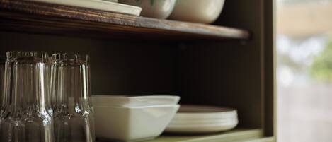 A shelf with glassware and dishes.