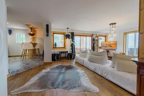 Ein großzügiger Wohnbereich mit Sofa, Teppich und einem Gemälde.