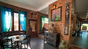 A room with brick walls, a Buddha statue, a traditional Chinese painting, and a wooden cabinet. - Golden Peach Villa Hoi An (Hoi An)