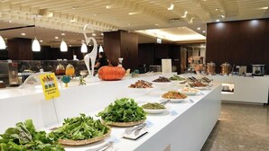 A buffet with various food items and fresh greens displayed on a white counter. - Best Hotel (Hualien City)
