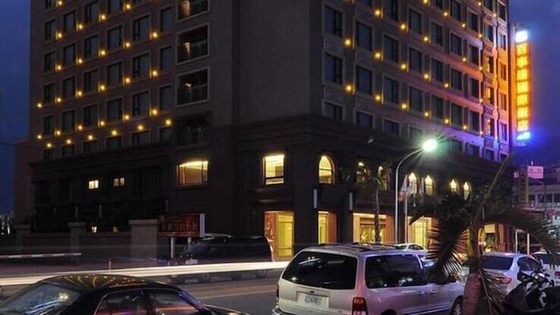 A multi-story hotel with a prominent vertical sign displaying the name in bright lights. - Best Hotel (Hualien City)
