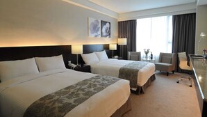 A hotel room with two beds, a desk, a chair, and a large window with curtains. - Best Hotel (Hualien City)
