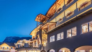 Un hôtel à plusieurs étages doté de balcons, de grandes fenêtres et d’espaces extérieurs aménagés pour s’asseoir.