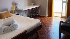 A hotel room with a bed, a desk, and a chair. - Mivô | Tejo Colours (Almada)