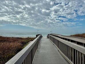 A wooden boardwalk leading to the beach with a cloudy sky above. - Beachfront Charm w/ Master on Gulf 2-BR w/ Free Golf Everyday! (Panama City Beach)
