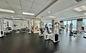 A gym with various exercise machines, large windows, and a view of the ocean. - Beachfront Charm w/ Master on Gulf 2-BR w/ Free Golf Everyday! (Panama City Beach)