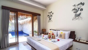 Une chambre spacieuse avec un grand lit, une petite table de chevet, une commode et une vue sur la piscine, visible à travers une porte vitrée.