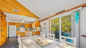 A modern kitchen with wooden cabinets and a large dining table set for six.
