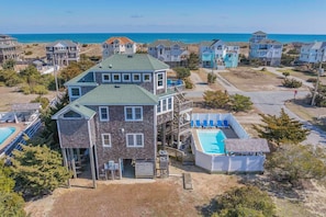 A multi-story house with a pool, surrounded by other houses, near a beach. - Semi-Oceanfront, Dog Friendly Home in Waves with Pool, Hot Tub, Game Room (Waves)