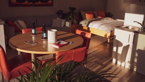 Un ambiente compatto con angolo ristoro, angolo cottura e un letto.