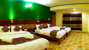 A hotel room with two beds, a TV, a mirror, and a bathroom with a shower curtain. - Hotel Adam (Pokhara)