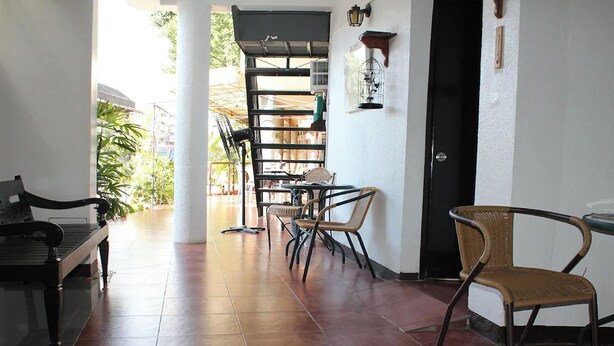 A spacious room with a bed, a dining area with chairs and a table, and a view of the outside. - Saint Nicolas Inn (Cagayan de Oro)