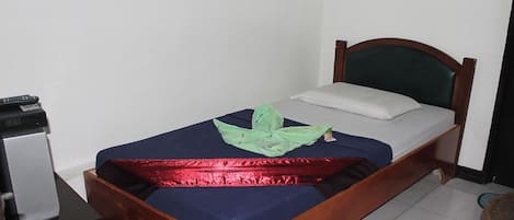 A single bed with a wooden frame, a blue mattress, and a green cloth on the bed.