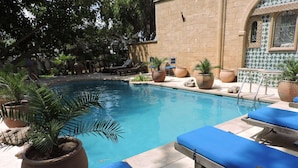 A pool area with lounge chairs and potted plants. - Villa Quietta (Essaouira)