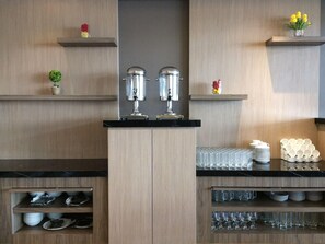 Una cocina con isla central, estantes con utensilios de cocina y elementos decorativos.
