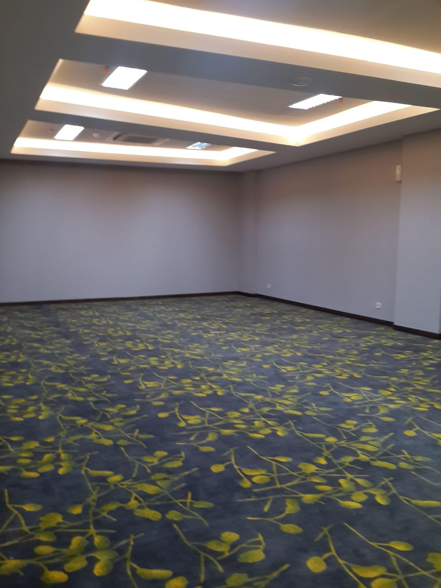 A room with a dark floor, light-colored walls, and a ceiling with recessed lighting.