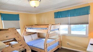 Una stanza con letto a castello, una scrivania e una lampada a sospensione.