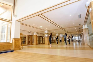 Un vaste studio de danse doté de planchers en bois et de murs recouverts de miroirs.