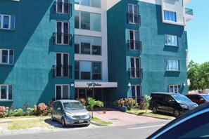A multi-story hotel with a teal facade, balconies, and a sign reading "The Delores."