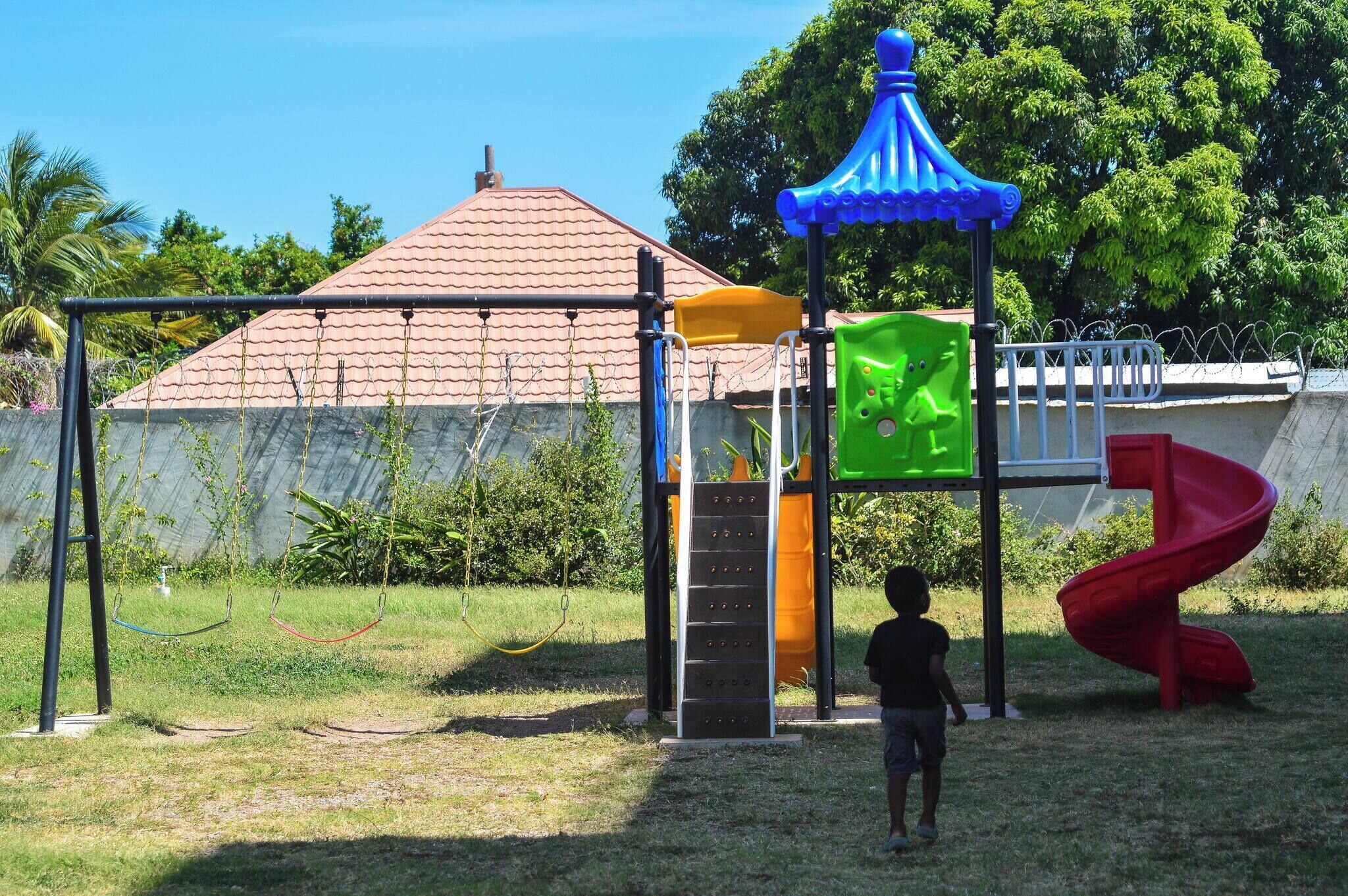 Un parque infantil con columpios, tobogán y estructura para escalar.