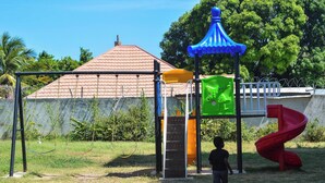 A playground with swings, a slide, and a climbing structure. - Resort Like Amenities - Accommodation In The City (Kingston)