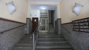 A staircase with granite steps and metal railings, leading to a door with a glass panel. - Suite 39 BnB (Salerno)