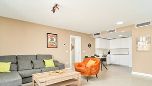 A living room with a grey sofa, a wooden coffee table, and an orange armchair. - 'Apartamento caracoles Duna Beach' with Sea View, Wi-Fi, and Air Conditioning (Torrox)